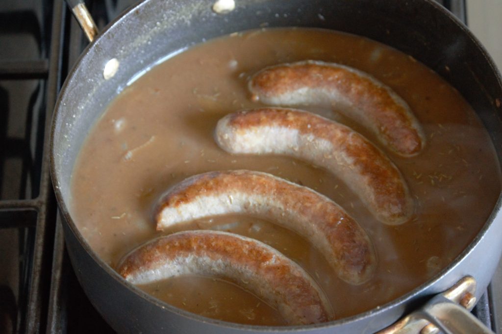 placing the bangers back in the gravy