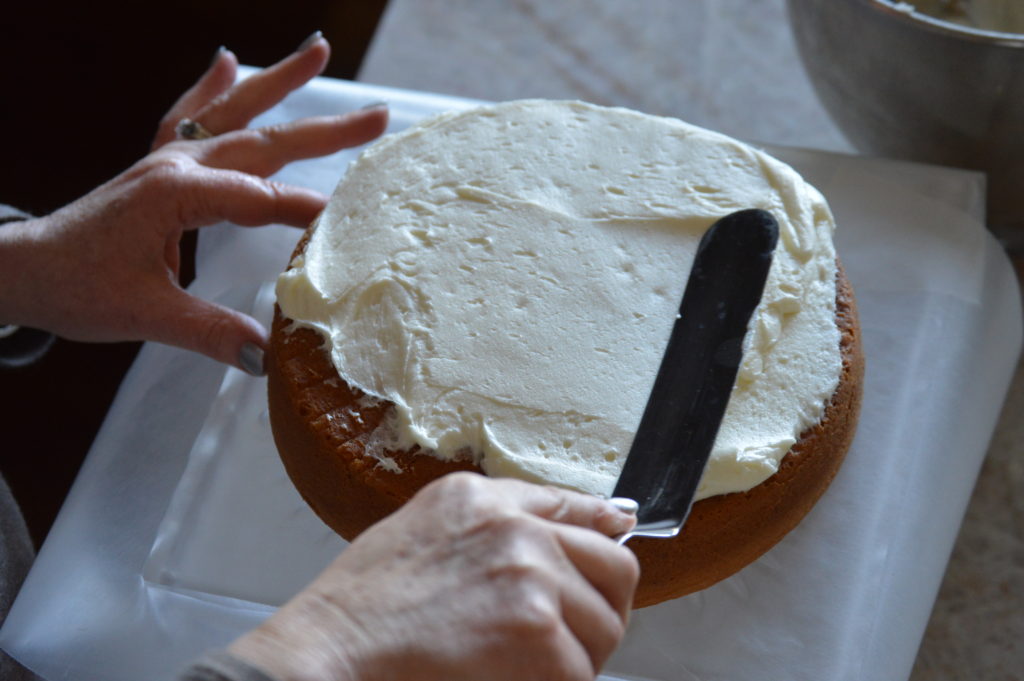 frosting the first layer of the cake