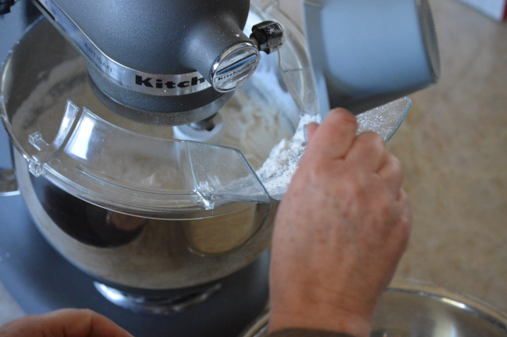 Adding the dry ingredients to the wet ingredients.