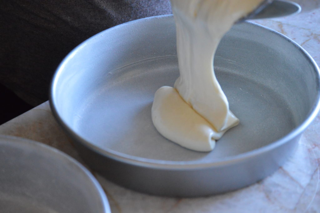 Poring batter into cake pan.