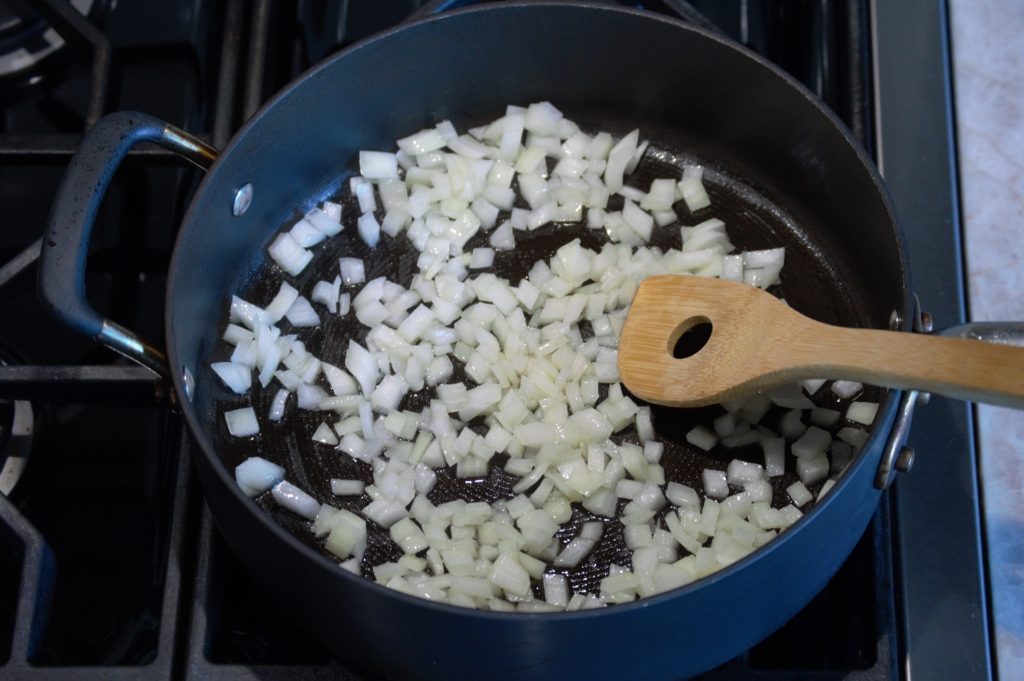 finely diced onions being sauteed in a pan