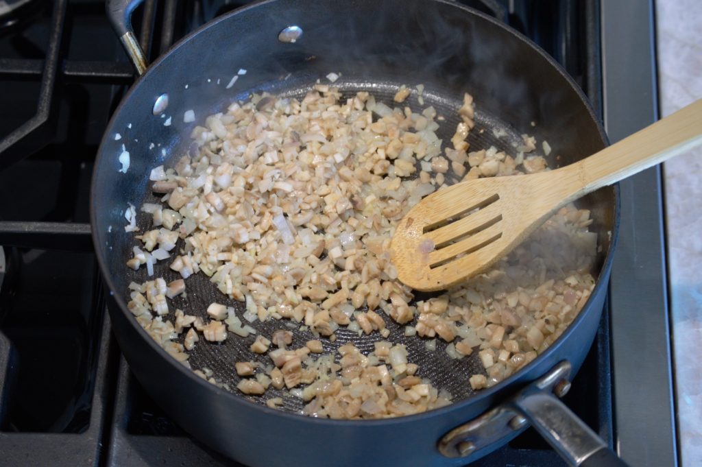 adding the mushroom stems in the pan