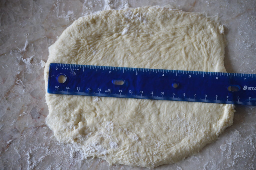 The pizza dough flattened out to 6 and a half inches wide