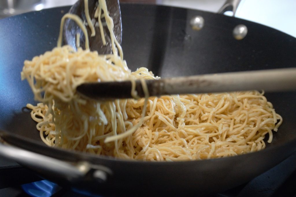The chow mein noodles being stir fried