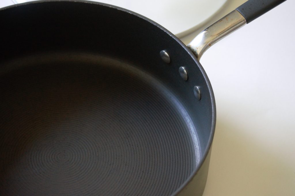 The sides of a saute pan showing the cookwares straight sides