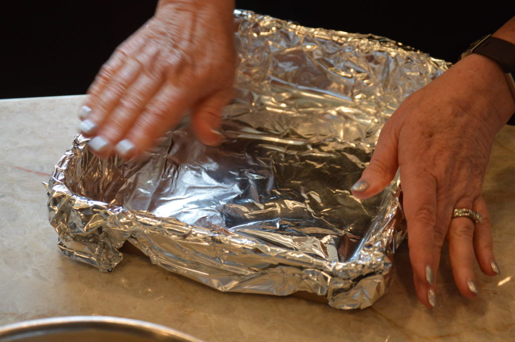 the baking pan with aluminum foil covering it