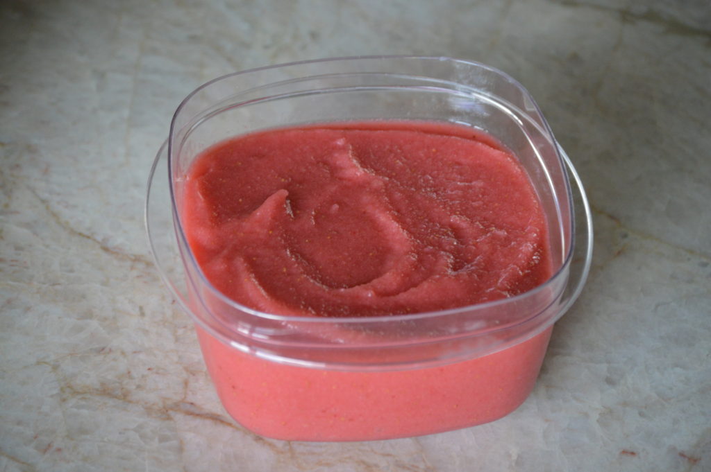 placing the strawberry vodka sorbet in a container