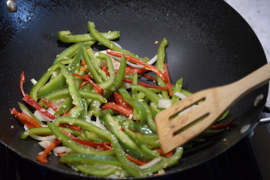 the bell peppers and onion are added to the wok