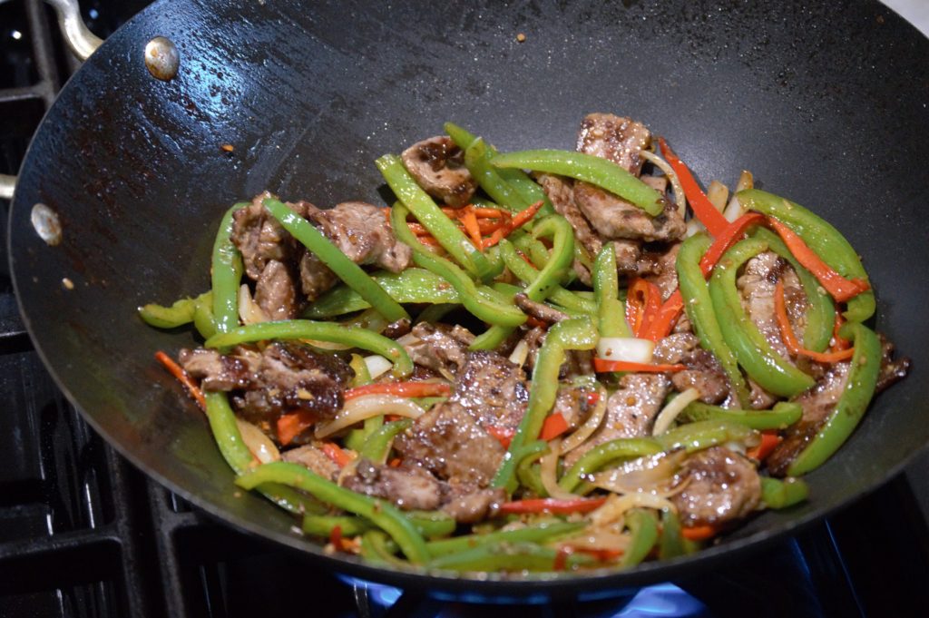the beef is added back to the wok