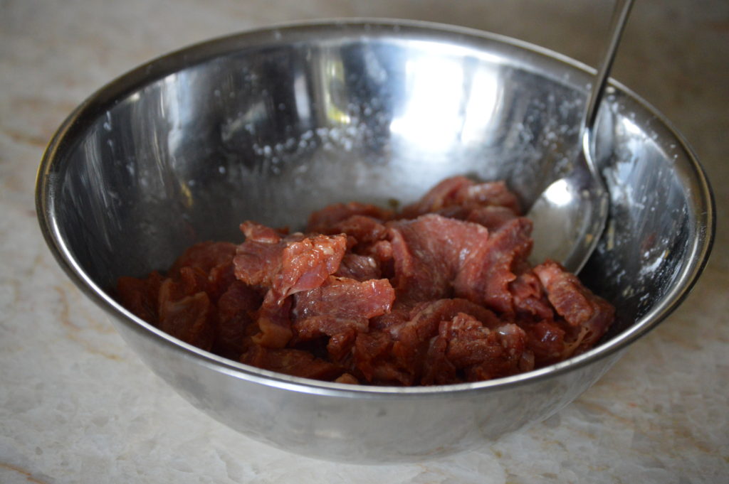 the beef marinating in a bowl