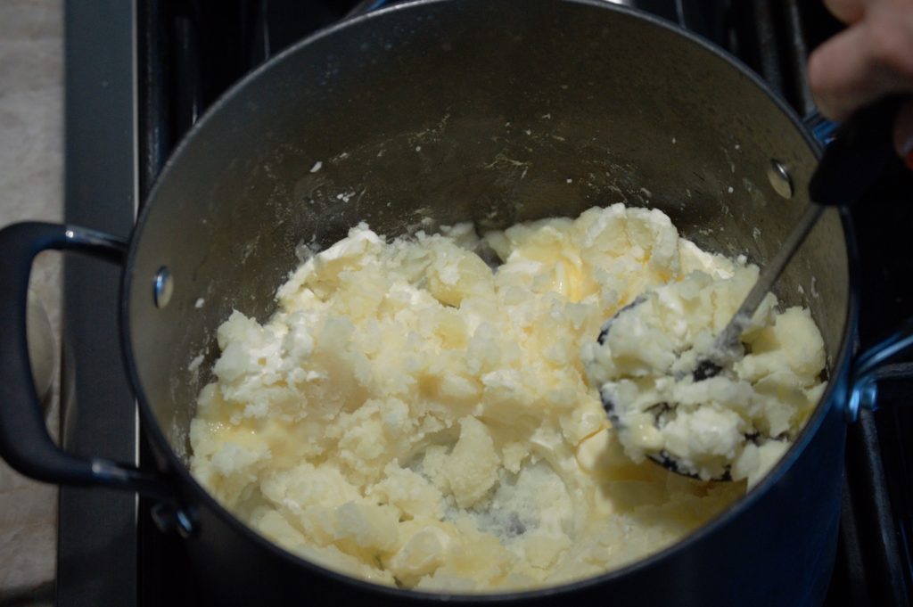 adding the butter and cream cheese, mashing it in.