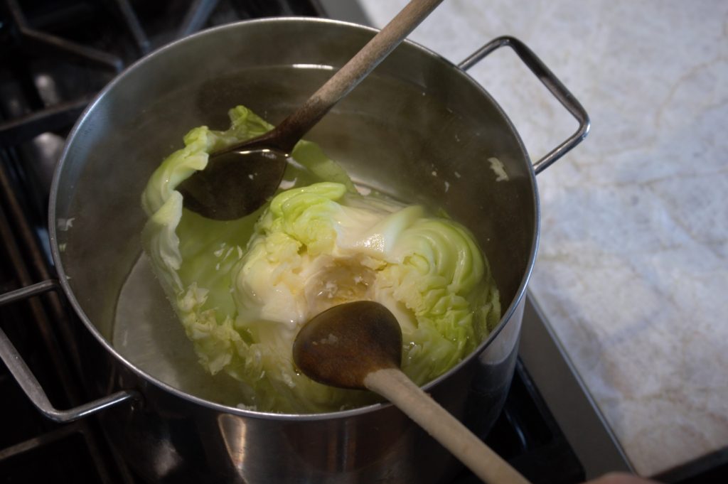 separating the cabbage leaves in a pot of water