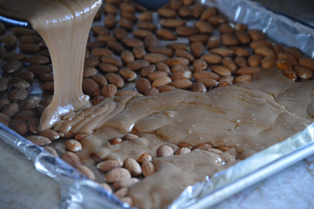 pouring the toffee over the almonds