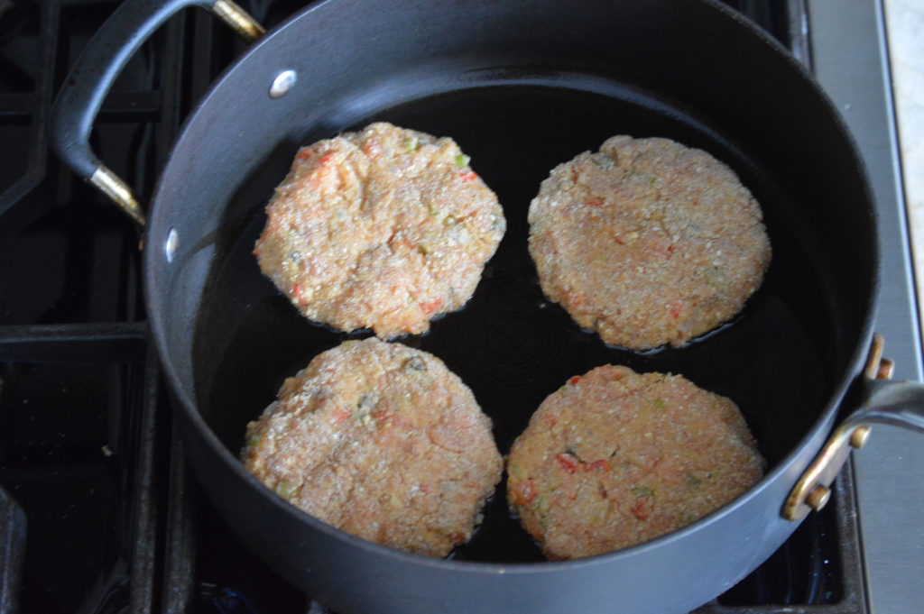 frying up the salmon cakes on the first side
