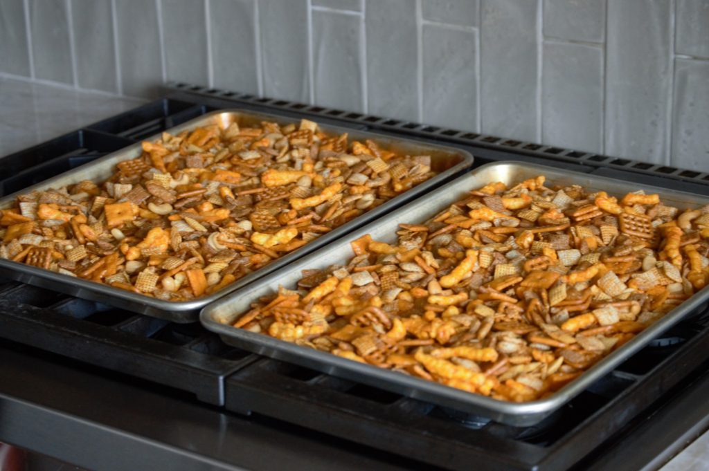 the snack mix on two baking sheets