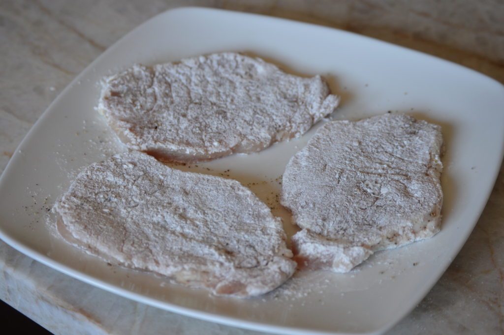 the pork chops dredged and ready for frying
