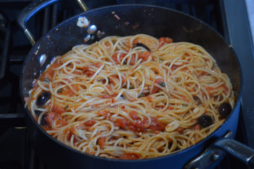 adding the pasta to the sauce