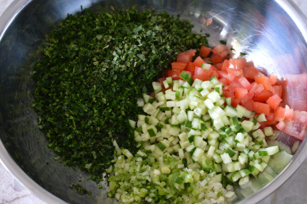 tomato, onion and cucumber added to the bowl