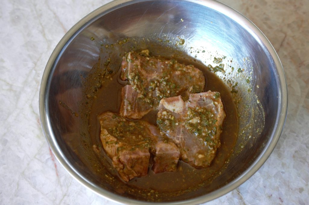marinating the lamb chops in a bowl