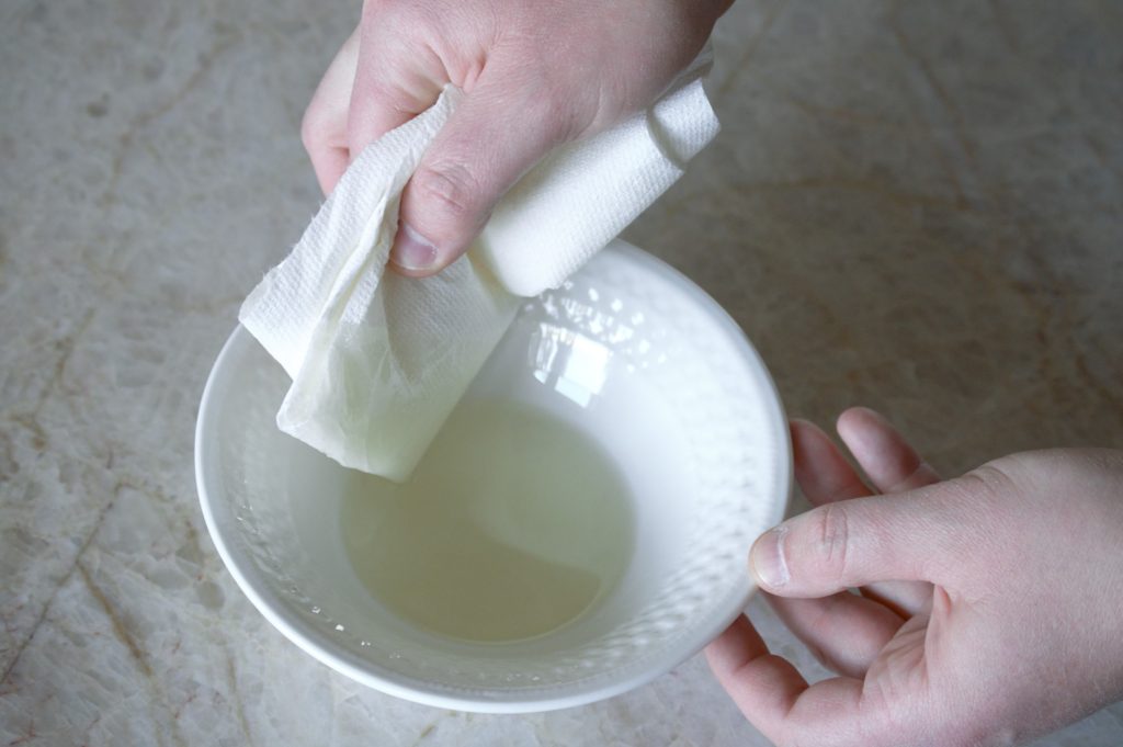 dipping a paper towel in oil
