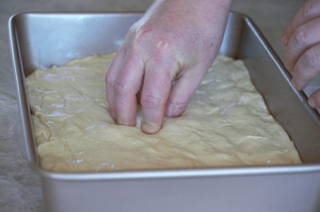 poking holes into the focaccia dough