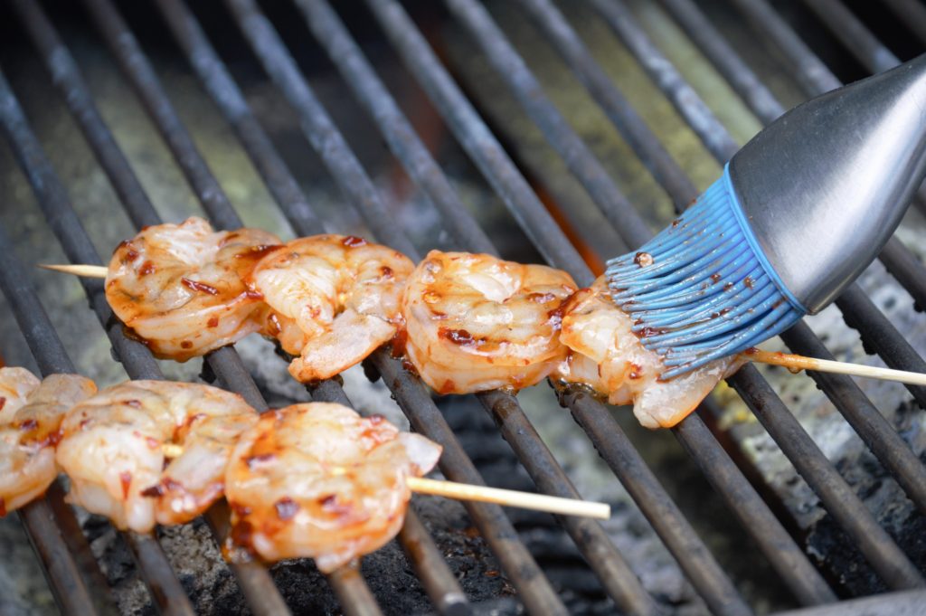 shrimp are on the grill and being basted