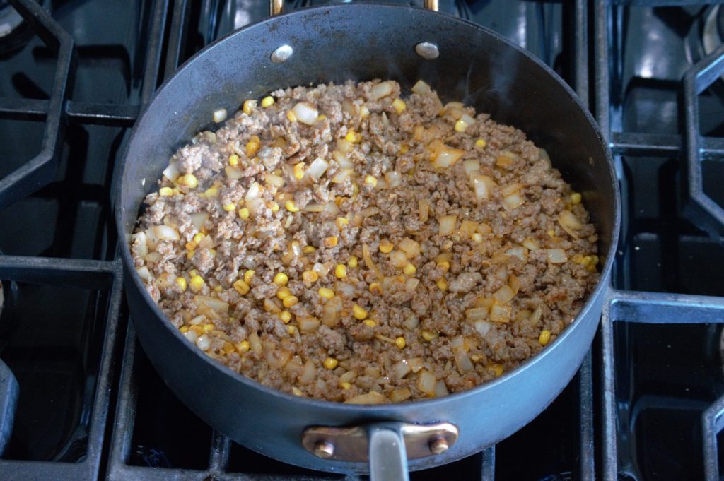 the onion, corn, and spices added to the pork
