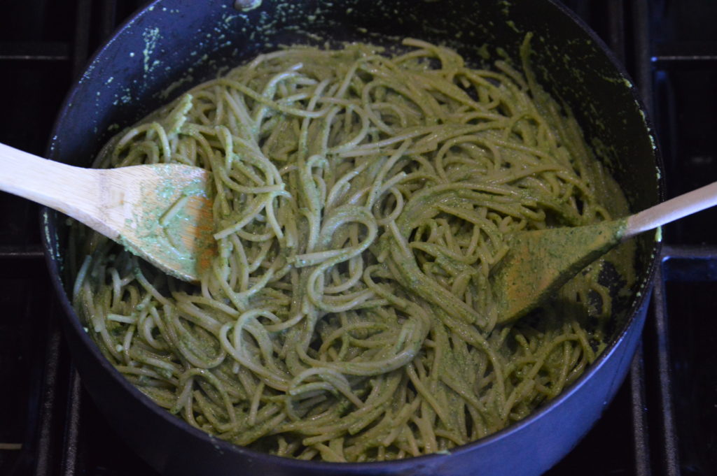 tossing the pasta in the sauce