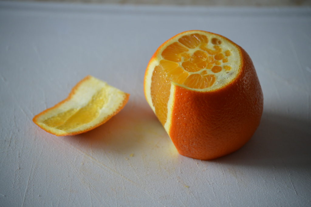 slicing off one side of the orange