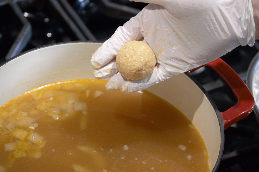 adding the matzo balls to the soup