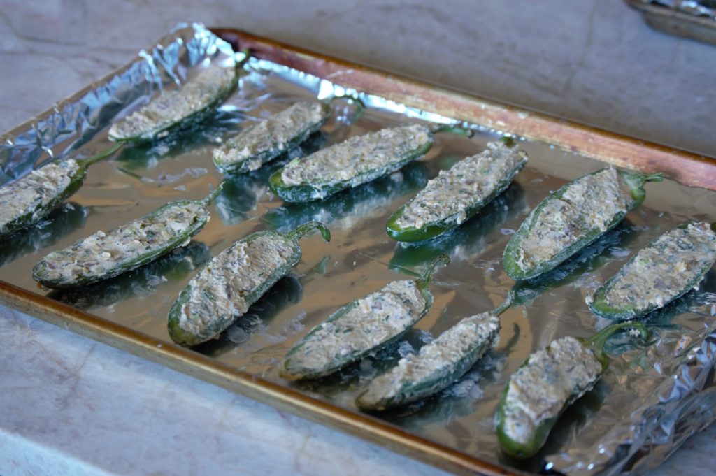 the stuffed jalapenos on a baking sheet