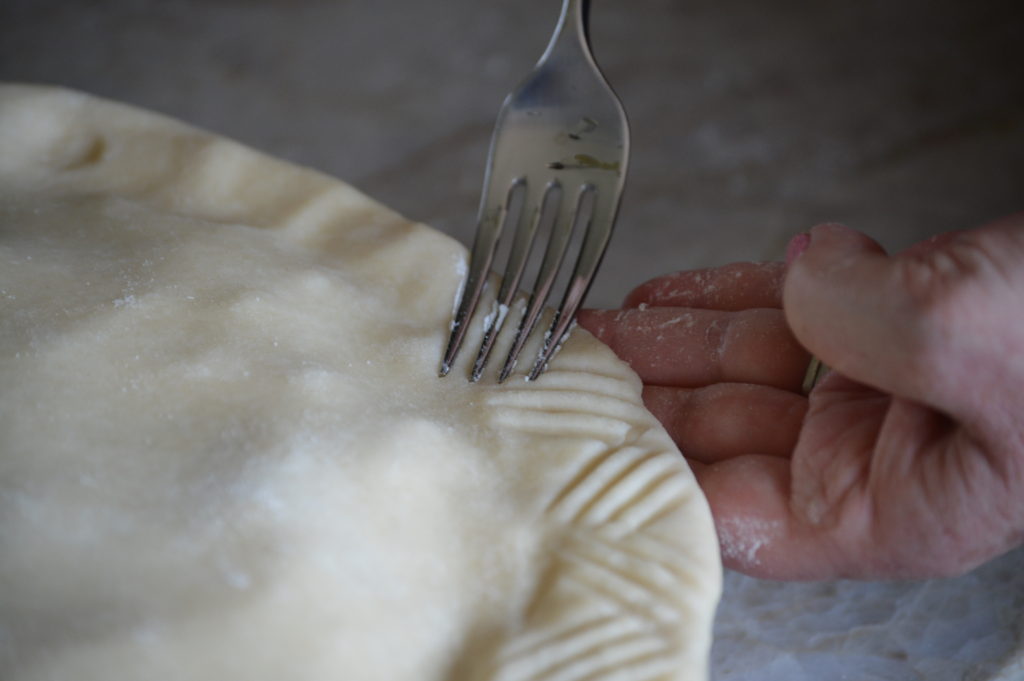 crimping the edge of the crust with a fork