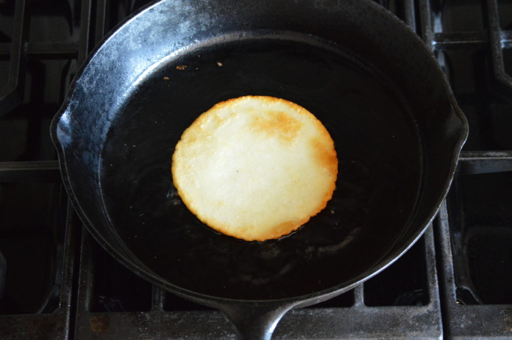 cooking up an arepa in a pan