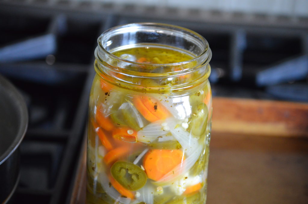 filling up a jar with the pickled vegetables