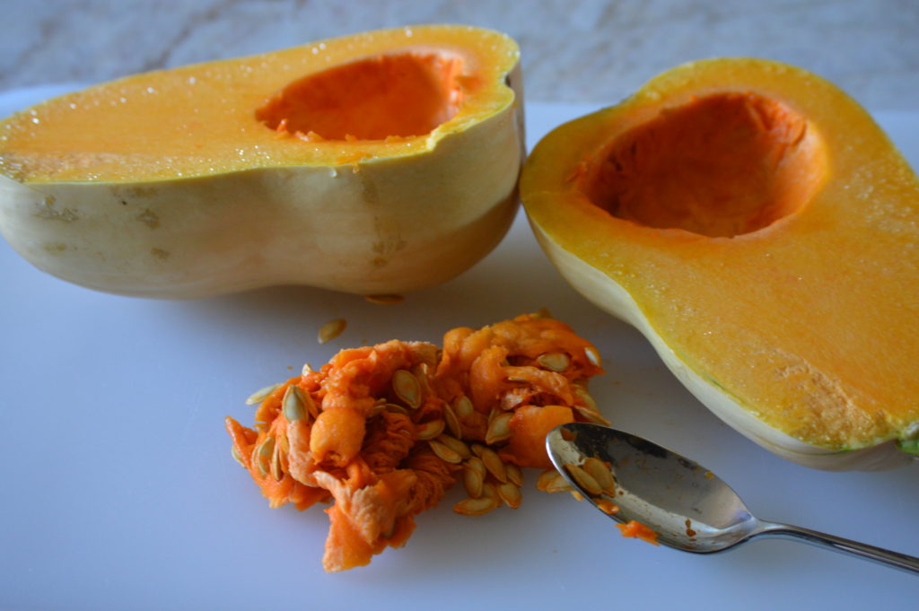 the butternut squash is cut in half and the seeds are removed