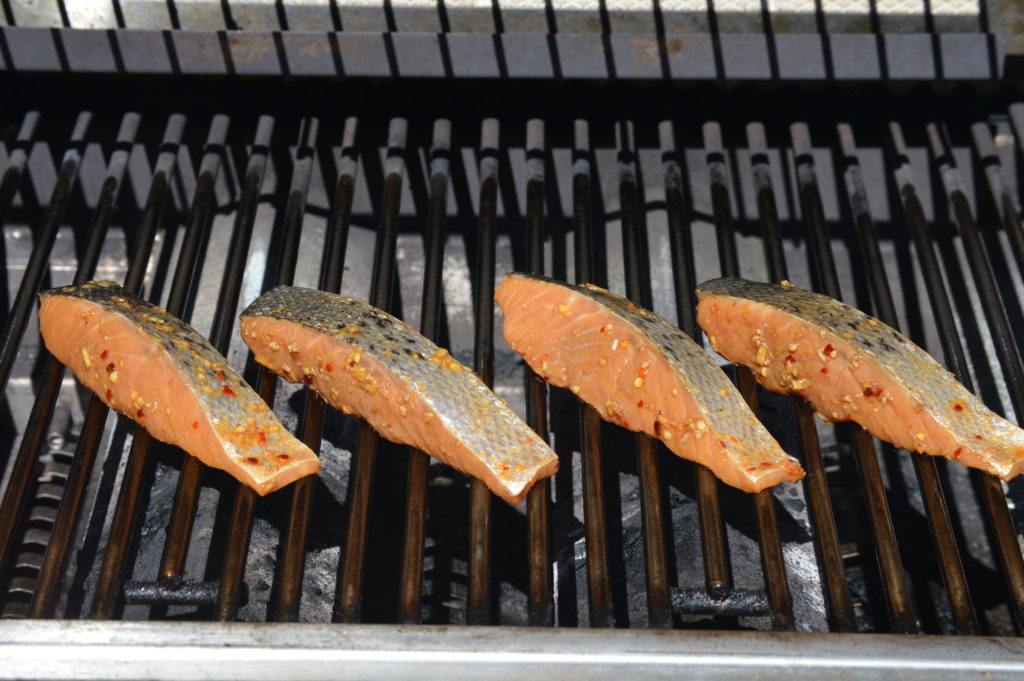 the salmon is placed on the grill flesh side down