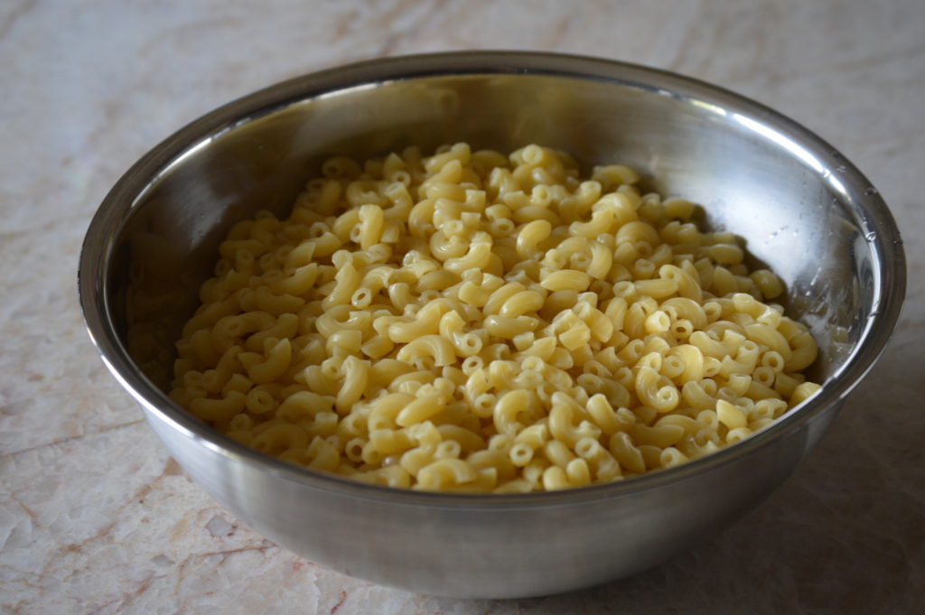 the macaroni pasta is cooked and set aside in a bowl