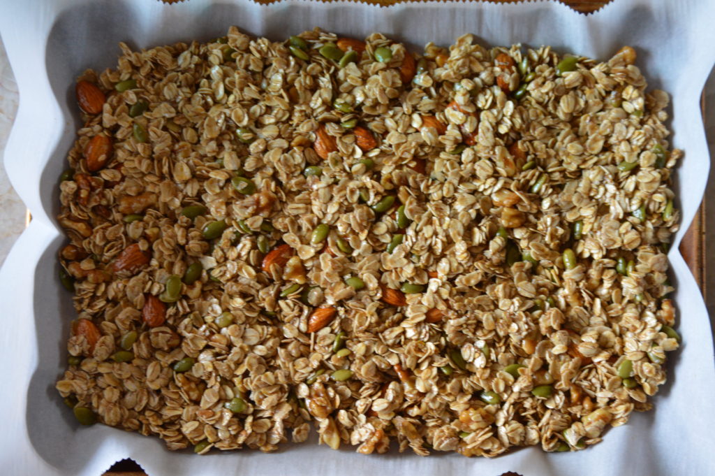the granola is layed out on a baking sheet