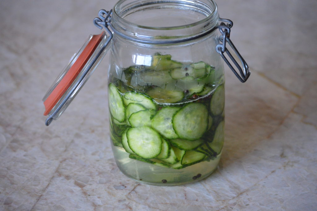 the pickeling liquid is poured over the cucumbers
