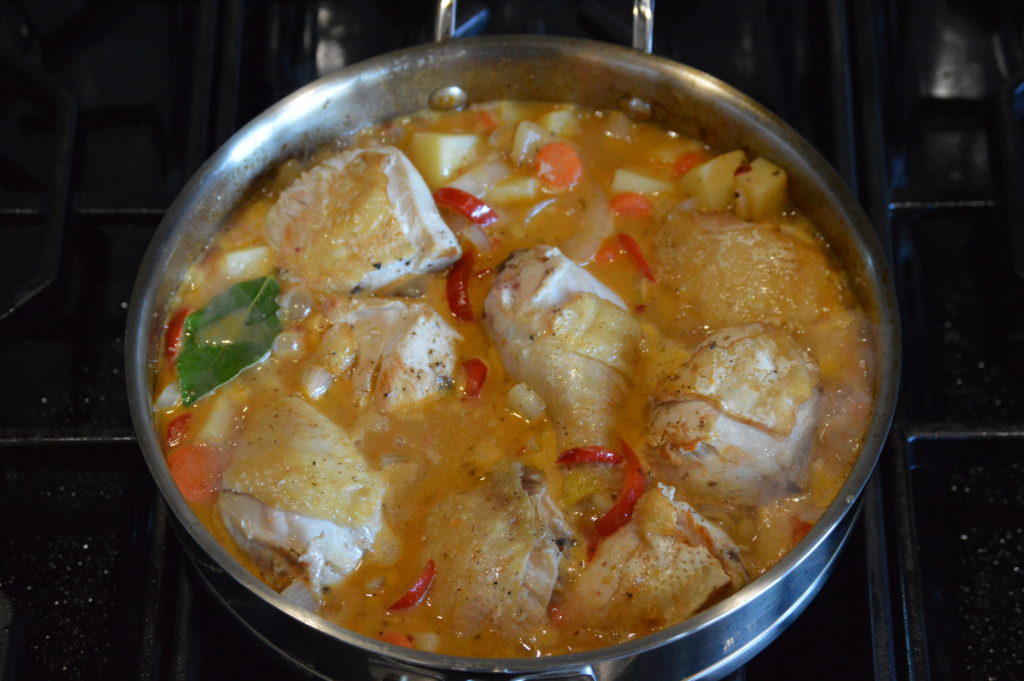 the chicken and braising liquids are added to the pan 