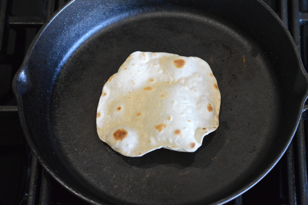 the flour tortilla is flipped and cooking on the other side