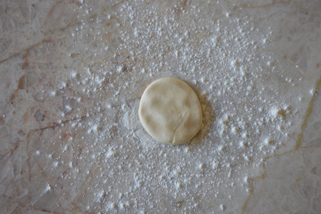 the tortilla dough ball is flattened
