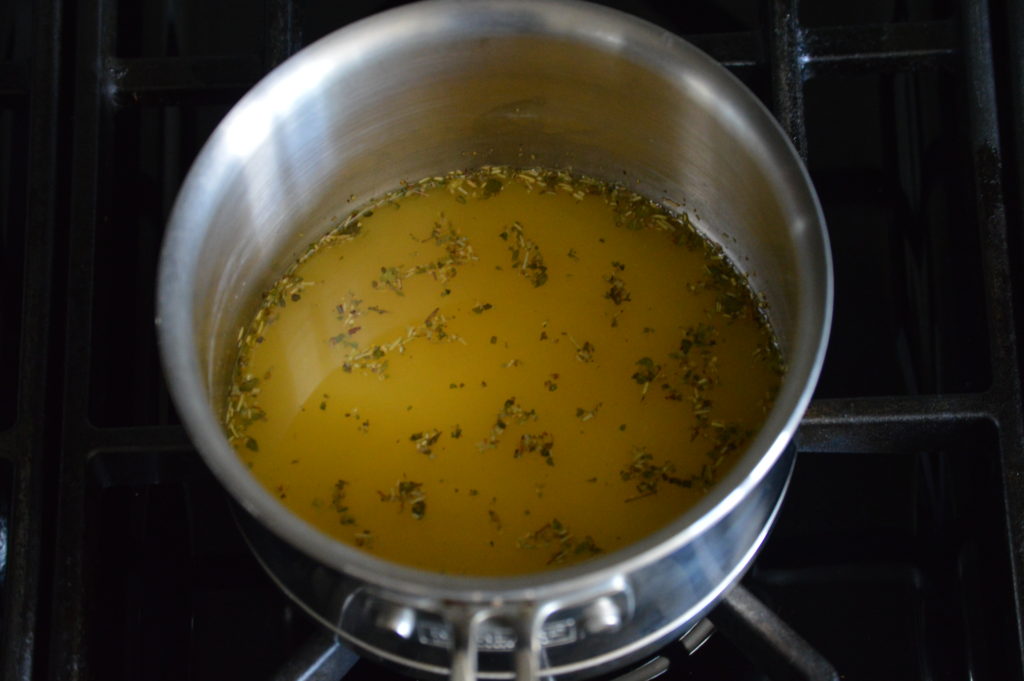 the chicken stock and herbs are mixed in a pot