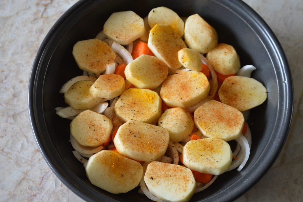 the base layer of vegetables is arranged in the tagine