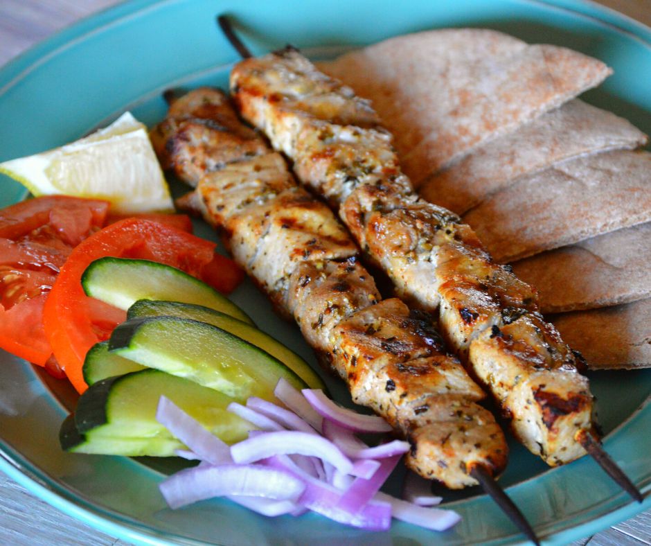 a plate of the finished pork souvlaki with pita and vegetables