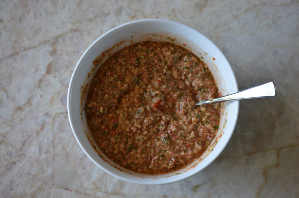 the cheese and olive oil are mixed into the pesto