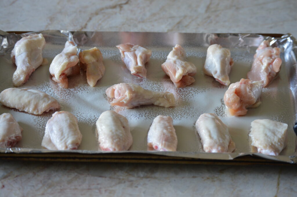 the wings arranged on a baking sheet