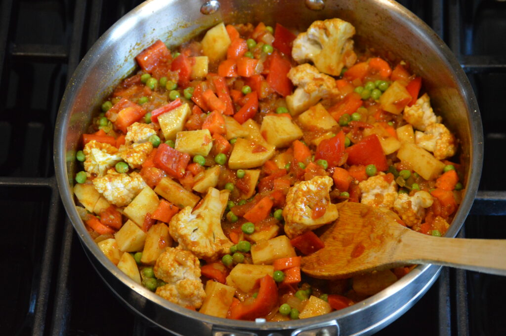 the vegetables are added and coated in the curry base
