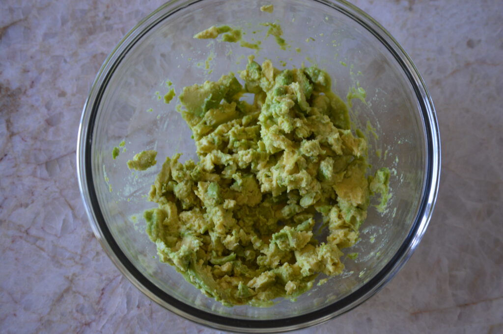 the avocados are mashed with salt and lime juice