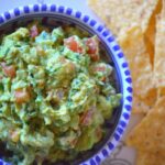 the finished guacamole in a bowl with some chips